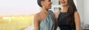 Une femme élégante souriante portant une robe de soirée scintillante dans une ambiance chaleureuse