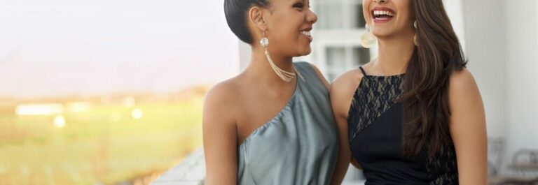 Une femme élégante souriante portant une robe de soirée scintillante dans une ambiance chaleureuse